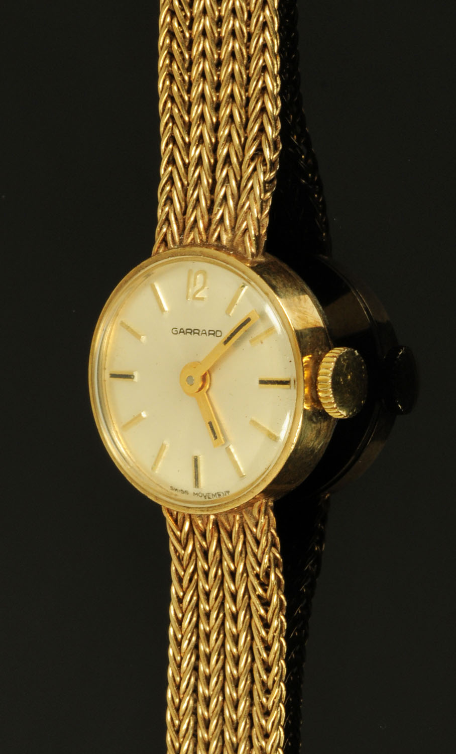A 9 ct gold wristwatch, by Garrard and complete with 9 ct gold mesh link strap. 16.4 grams gross.