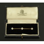 A gold coloured diamond set bar brooch, the original case stamped "Edwards & Sons Ltd., Glasgow".