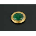 A gold coloured brooch, set with a malachite to decorative oval mount.