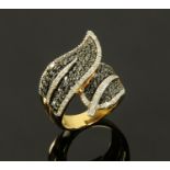 A 9 ct gold dress ring, with two overlapping leaves in black and clear stone, size P.
