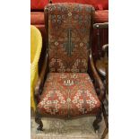 An early Victorian mahogany framed salon chair upholstered in red ground carpet raised on cabriole