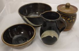 A John Bedding Studio Pottery bowl and jug finished with a white curved pattern on a dark treacle