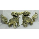 A pair of Chinese polished bronze Dog of Fo figures, one with left paw upon a lattice work ball,