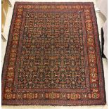 A Caucasian rug, the midnight blue ground with all over repeating pattern in burnt red and cream,