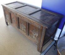 An 18th Century oak coffer with four diamond carved panels to the front raised on stile feet