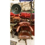 An early 20th Century Captain style chair with leather upholstered back raised on four legs to