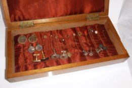 An oak box opening to reveal various cufflinks and tie pins, to include one 9 carat gold cufflink,