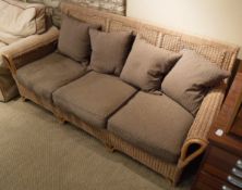 A modern rattan three seat conservatory sofa with brown and fawn upholstery