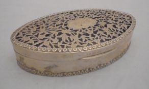 A George V silver box of oval form with pierced foliate decorated lid,