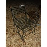 A pair of wrought iron slatted chairs and small table