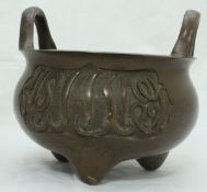 A Chinese patinated bronze censer with two loop handles,