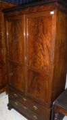 A circa 1900 mahogany wardrobe, the upper section with panelled doors enclosing a hanging space,