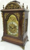 A Continental walnut cased mantle clock, the eight day movement with brass arched dial,