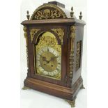 A Continental walnut cased mantle clock, the eight day movement with brass arched dial,