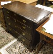 An oak chest of four long graduated drawers flanked by fluted quarter cut side pilasters on bracket