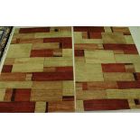 Two modern rugs of yellow, red and terracotta etc colours in an abstract square pattern,