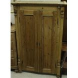 A Continental pine two door armoire with ogee shaped pediment and moulded pilasters and panelled