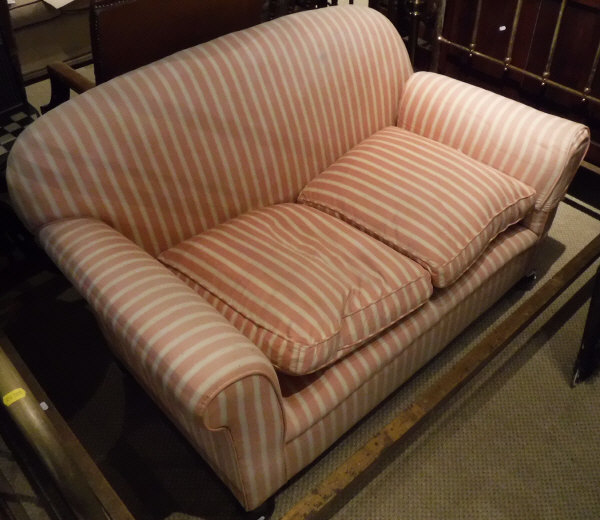 A Victorian drop-arm sofa with pink and cream striped upholstery,