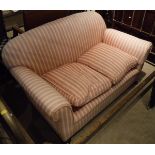 A Victorian drop-arm sofa with pink and cream striped upholstery,