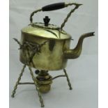 A brass spirit kettle on stand with turned wooden handle on a bobbin decorated X frame to base with