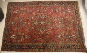A Caucasian rug, the central panel set with all over floral design on a red ground,