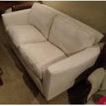 A modern Wesley Barrell two seat sofa with cream upholstery,