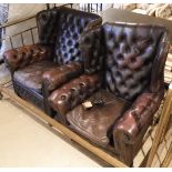 A pair of leather button back club chairs,
