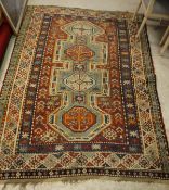 A Kazak rug, the central panel set with four repeating medallions on an aqua blue ground,