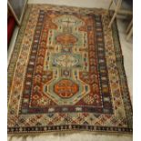 A Kazak rug, the central panel set with four repeating medallions on an aqua blue ground,