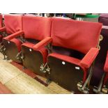 A set of three gold painted cast iron framed folding theatre seats with upholstered back,