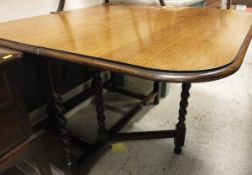 An early 20th Century oak rounded rectangular gate-leg drop-leaf dining table on barley-twist