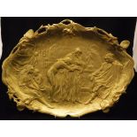 A gilt metal dish in the Art Nouveau manner depicting a slave trader inscribed within the casting