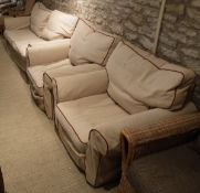 A modern three piece suite comprising three seat sofa and two single chairs in oatmeal upholstery