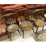 A Harlequin set of six stick back beech and elm kitchen chairs to include one carver,