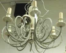 A modern cream painted wrought iron and wooden six branch electrolier with scroll work decoration