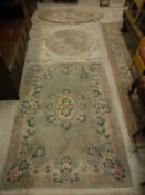 A Chinese superwash rug, the central panel set with floral decorated medallion on a sage ground,