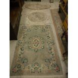 A Chinese superwash rug, the central panel set with floral decorated medallion on a sage ground,