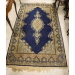 A midnight blue ground Kashan rug with central light oatmeal ground medallion in cream, pale pink,