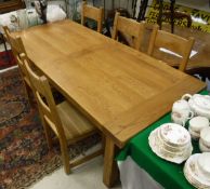 A modern oak dining table with a set of five oak dining chairs