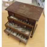 A mahogany four draw collector's cabinet containing a quantity of fly tying materials