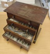 A mahogany four draw collector's cabinet containing a quantity of fly tying materials