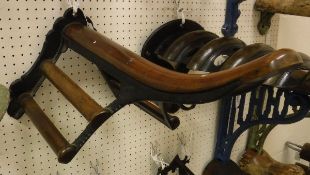 A painted cast iron and mahogany mounted Musgrave wall-mounted saddle rack with associated bridle