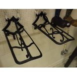 A pair of painted cast iron wall-mounted saddle racks,