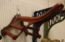 A painted cast iron wall-mounted saddle rack with mahogany mounts by Musgrave