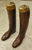 A pair of brown leather cubbing boots with wooden trees,