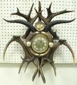 A brassed barometer housed in decorative antler frame with eagle finial
