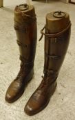 A pair of brown field boots with wooden trees,