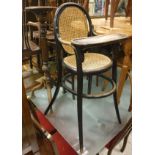 A circa 1900 ebonised and cane bentwood high chair in the manner of Thonet together with an