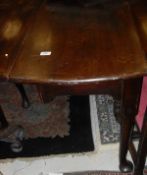 A George III mahogany oval drop-leaf dining table on turned tapering legs to heavy pad feet