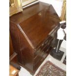 An early 19th Century oak bureau with fitted interior over two short and two long drawers to